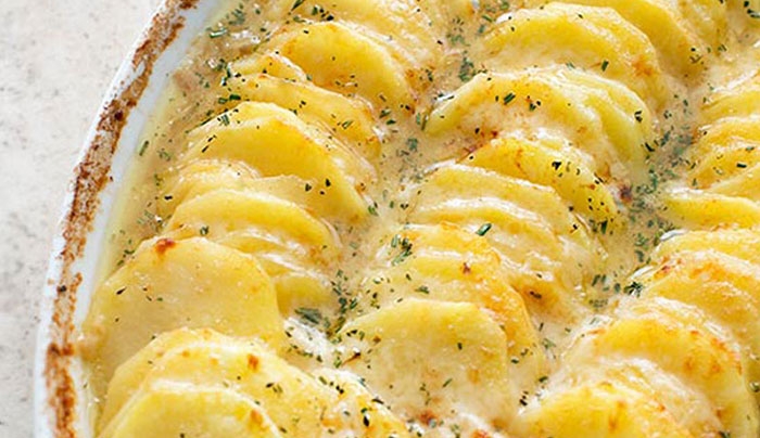 Πατάτες στον φούρνο με καραμελωμένα κρεμμύδια και τυριά