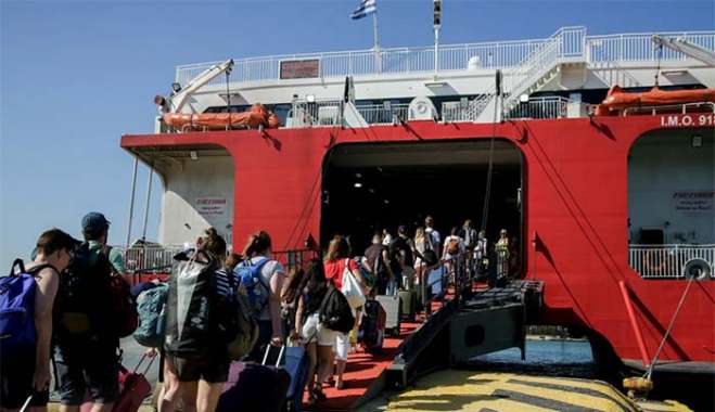 Ταξιδιώτες επιβιβάζονται σε πλοίο στο λιμάνι του Πειραιά © Eurokinissi