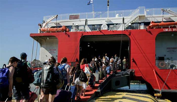 Ταξιδιώτες επιβιβάζονται σε πλοίο στο λιμάνι του Πειραιά © Eurokinissi